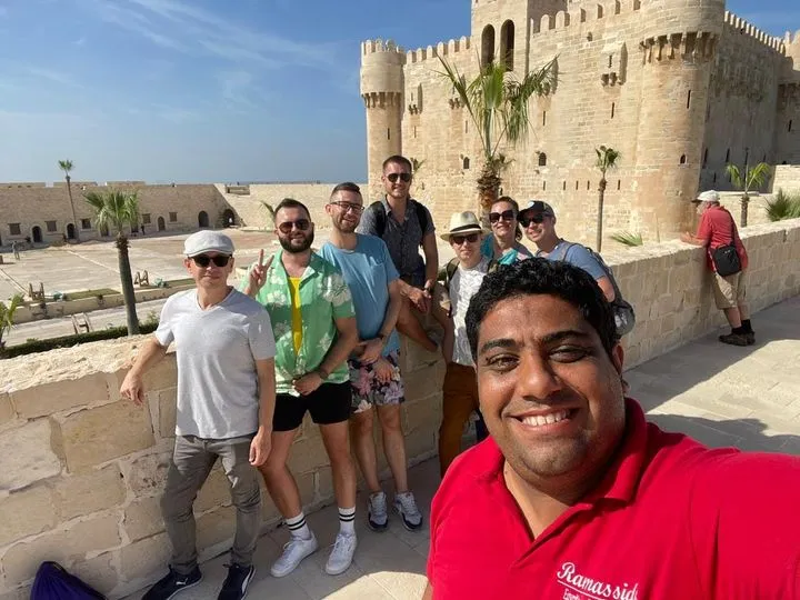 A large tour group from Ramasside Tours posing in front of the Great Pyramids of Giza during a day trip from Alexandria.