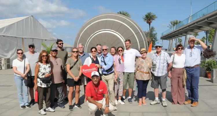 A group of happy travelers posing in front of the modern Bibliotheca Alexandrina, a major cultural landmark and modern tribute to the ancient Library of Alexandria.
